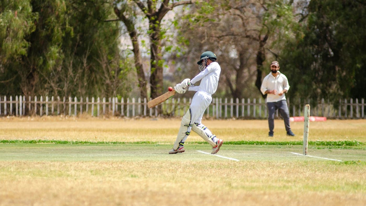 Batsman playing a shot on a cricket ground