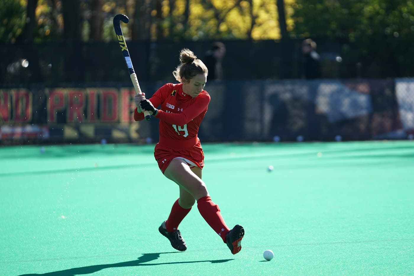 Field hockey player striking the ball on turf