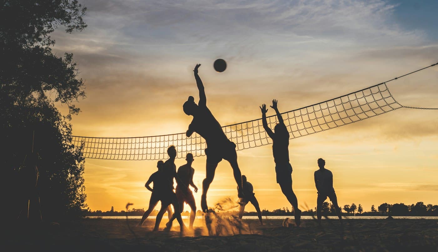 Volleyball players silhouetted at sunset